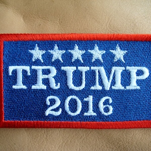 May include: A blue and red embroidered patch with white stars and the text "TRUMP 2016".