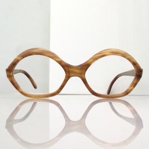 May include: A pair of brown tortoiseshell eyeglasses with round, octagonal frames.