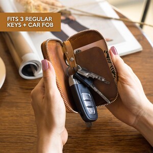 Leather key organizer wallet open showing space for 3 regular keys and car fob, compact zipper key case for everyday carry