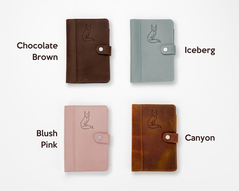 Pode incluir: Quatro cadernos de couro em v&aacute;rias cores: castanho chocolate, iceberg, rosa blush e canyon. Cada caderno apresenta uma ilustra&ccedil;&atilde;o de raposa e um fecho de bot&atilde;o. As cores s&atilde;o rotuladas com o texto: "Chocolate Brown", "Iceberg", "Blush Pink" e "Canyon".
