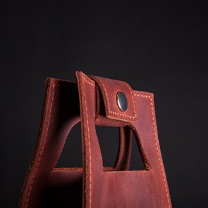 Close up of snapped leather handle on personalized wine bottle carrier, durable anniversary wine gift for husband or boyfriend
