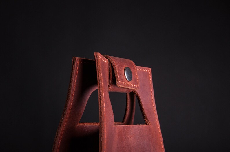 Close up of snapped leather handle on personalized wine bottle carrier, durable anniversary wine gift for husband or boyfriend