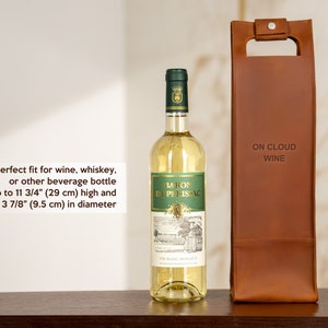 Leather wine bottle carrier shown next to standard wine bottle illustrating fit for anniversary wine gift and romantic dinner presentation