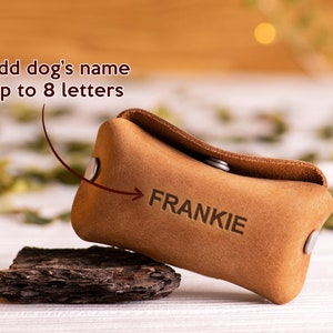 May include: A brown leather dog treat pouch with the name "FRANKIE" embossed on it. The pouch is designed to hold dog treats and can be personalized with up to 8 letters.