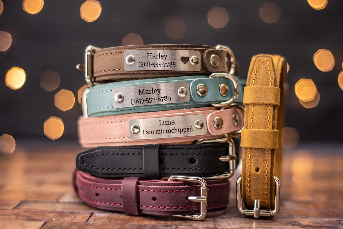 A stack of personalized leather dog collars in various colours.