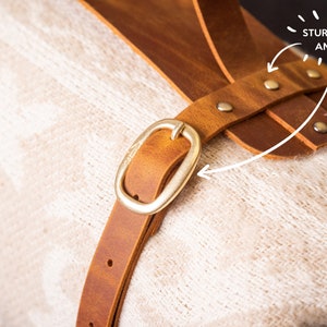 Close up of sturdy buckle and rivets on leather blanket carrier, durable anniversary gift for outdoors loving couple