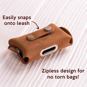 May include: A brown leather dog poop bag holder with a snap closure. The holder has a zipless design and is easily attached to a leash.