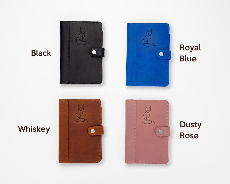 Pode incluir: Quatro cadernos de couro em preto, azul royal, whisky e rosa empoeirado. Cada caderno apresenta uma ilustra&ccedil;&atilde;o de raposa e um fecho de press&atilde;o. As cores s&atilde;o rotuladas com texto: Preto, Azul Royal, Whisky e Rosa empoeirado.