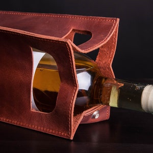Handcrafted leather wine bottle holder with structured interior, personalized anniversary wine carrier for couples shown holding standard wine bottle