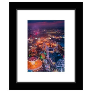 May include: An aerial view of a carnival at night. The image shows a Ferris wheel, a roller coaster, and a carousel. The carnival is lit up with colorful lights. The sky is dark blue with a hint of pink.