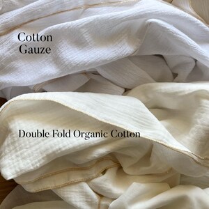 May include: Four different types of white fabric swatches with gold trim. The fabrics are labeled "Rayon Gauze", "Cotton Gauze", "Double Fold Organic Cotton", and "Cotton Voile".