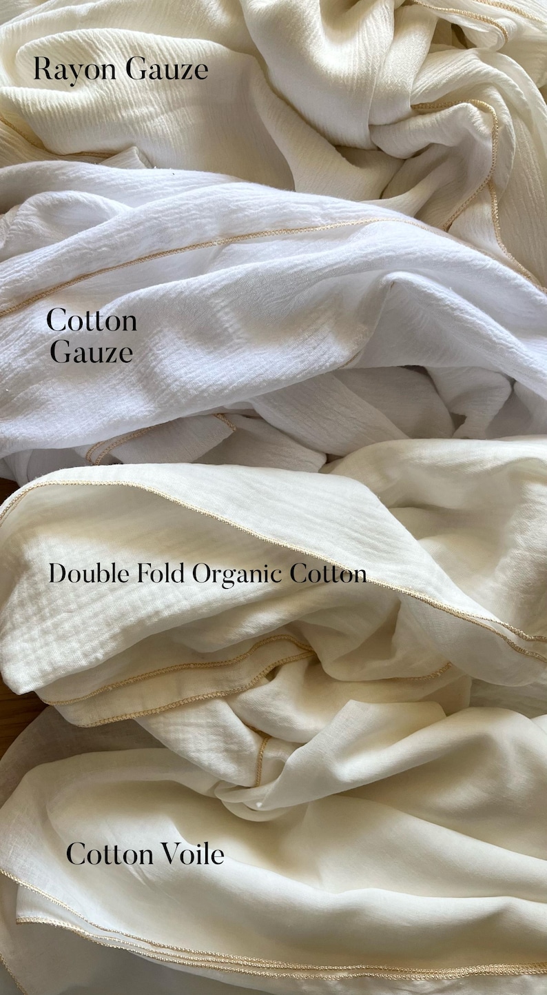 May include: Four different types of white fabric swatches with gold trim. The fabrics are labeled "Rayon Gauze", "Cotton Gauze", "Double Fold Organic Cotton", and "Cotton Voile".