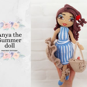 May include: Anya the Summer doll crochet pattern. A crocheted doll with brown hair, a blue and white striped dress, and a brown crocheted bag.