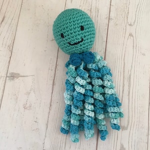 May include: A crocheted octopus toy with a smiling face and blue and green tentacles.