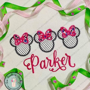 May include: Embroidered design featuring three pink and white polka dot Minnie Mouse heads with pink bows. The name "Parker" is embroidered in pink below the Minnie Mouse heads.