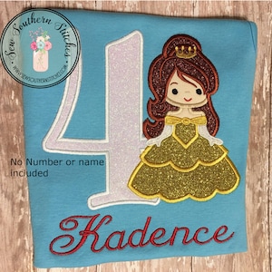 May include: A light blue t-shirt with a white number four and a glittery gold princess applique. The princess has brown hair, a gold crown, and a yellow dress. The name "Kadence" is embroidered in red below the number.