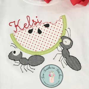 May include: A white t-shirt with a watermelon and two ants embroidered on it. The watermelon is green and red with white polka dots. The ants are black and white checkered. The text "Kels" is embroidered above the watermelon. The text "Sew Southern Stitches" is embroidered below the watermelon.