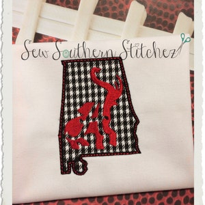 May include: Embroidered design of the state of Alabama in black and white gingham with a red Alabama Crimson Tide logo. The design is on a white fabric background.