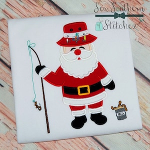 May include: Embroidered design of a Santa Claus wearing a red and white fishing hat, holding a fishing rod with a worm on the line. He is wearing a red suit with a black belt and white trim. He is standing next to a small bucket of bait.