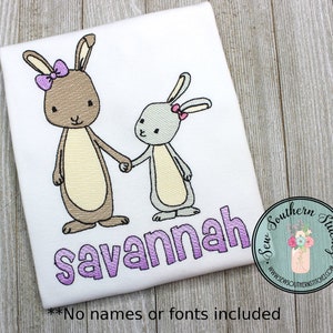 May include: Embroidered design of two bunnies holding hands with a purple name "savannah" below. The design is on a white t-shirt.