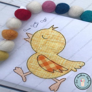 K&ouml;nnte beinhalten: Ein gelbes K&uuml;ken mit orange-wei&szlig;en karierten Fl&uuml;geln singt mit geschlossenen Augen. Das K&uuml;ken ist auf einen wei&szlig;en Stoffhintergrund gestickt. Das Bild enth&auml;lt den Text "Sew Southern Stitches" mit einem kleinen Blumentopf und dem Text "Where Southern Stories Start".