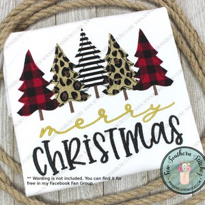 May include: White t-shirt with an embroidered design of three Christmas trees. The trees are decorated with red and black buffalo plaid, leopard print, and black and white stripes. The text "merry christmas" is embroidered in gold and black.
