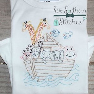 May include: Embroidered design of Noah's Ark with animals on a white t-shirt. The ark is brown with a blue roof. The animals include a giraffe, a hippopotamus, and elephants. The text "Sew Southern Stitchez" is embroidered in green on the shirt.