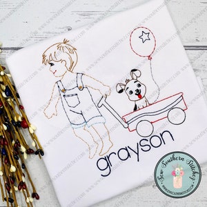 Può includere: Disegno ricamato di un bambino che tira un carrello rosso con un cane dentro. Il carrello ha un palloncino blu a forma di stella attaccato. Il bambino indossa una salopette e il cane indossa un collare. Il testo "grayson" è ricamato sotto il carrello.