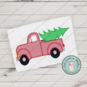 May include: Red pickup truck with a green Christmas tree in the bed. The truck has black wheels and a white background.