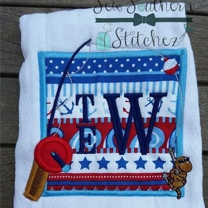 Könnte beinhalten: Weißes, besticktes Handtuch mit nautischem Thema. Es zeigt ein zentrales Quadrat mit den Buchstaben "TEW" in Marineblau, umgeben von roten, weißen und blauen Mustern, darunter Anker und Sterne. Eine Angelrute und ein Cartoon-Wurm sind befestigt.