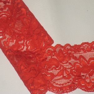 May include: Red lace trim with a floral pattern.
