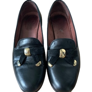 Mocasines vintage años 80 en piel negra con lazos de ante y detalles en latón. Talla 7AU.