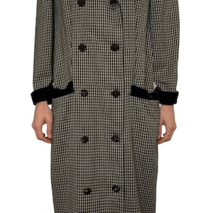 May include: A long black and white gingham coat with a black velvet collar and cuffs. The coat has a double breasted closure with black buttons.