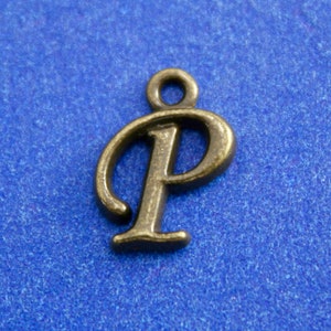 May include: A bronze-colored metal charm in the shape of the letter "P".