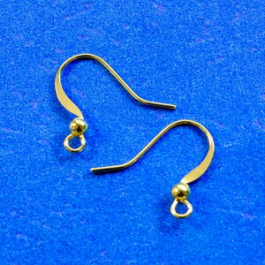 May include: Two gold-toned earring hooks with a small ball at the end of each hook.