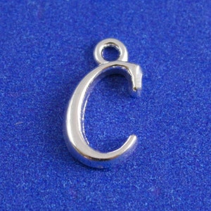 May include: Silver charm in the shape of the letter C. The charm has a loop at the top for attaching to a bracelet or necklace.