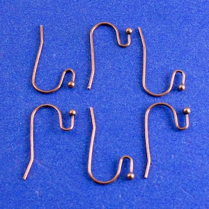 May include: Four copper earring hooks with small round balls at the end of each hook.