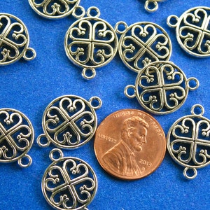 May include: Silver tone metal charms with a four-leaf clover design. The charms have two jump rings for attaching to jewelry or other crafts.