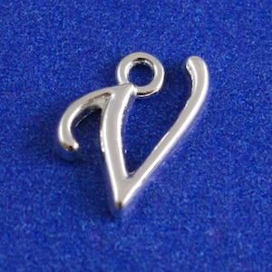 May include: Silver charm in the shape of the letter V. The charm has a loop at the top for attaching to a bracelet or necklace.