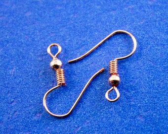 May include: Two gold-toned earring hooks with a spring coil and a small ball at the top.