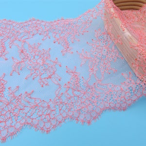 Peut inclure: Galon de dentelle rose et blanc avec un motif floral d&eacute;licat. La dentelle est douce et transparente, avec un bord festonn&eacute;.