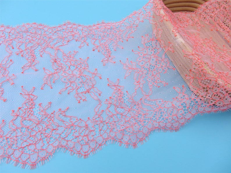 Peut inclure: Galon de dentelle rose et blanc avec un motif floral d&eacute;licat. La dentelle est douce et transparente, avec un bord festonn&eacute;.