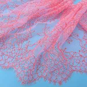 Peut inclure: Tissu de dentelle rose et blanc avec un motif floral d&eacute;licat. La dentelle a un bord festonn&eacute; et est douce et transparente.