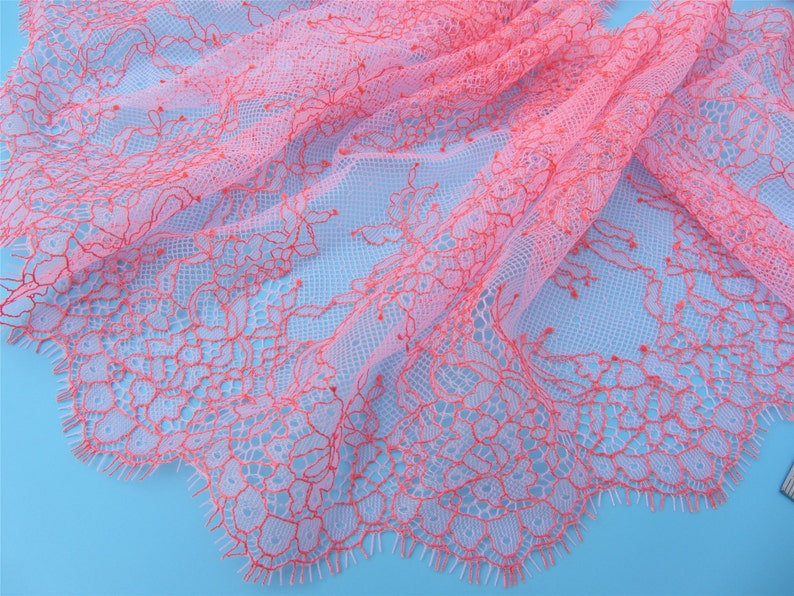 Peut inclure: Tissu de dentelle rose et blanc avec un motif floral d&eacute;licat. La dentelle a un bord festonn&eacute; et est douce et transparente.