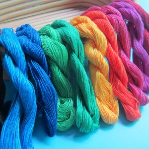 May include: A selection of vibrant embroidery threads in a spectrum of colours, from black to pink. The threads are displayed in a neat arrangement, highlighting their rich hues and textures. Suitable for various craft projects.