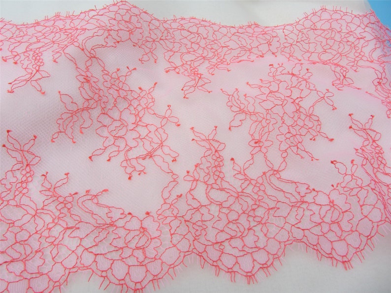 Peut inclure: Dentelle rose avec un motif floral d&eacute;licat. La dentelle est faite d'un tissu transparent avec un design fin et complexe.