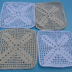 May include: Four crocheted square placemats in two colors: white and beige. The placemats have a delicate, lacy pattern.