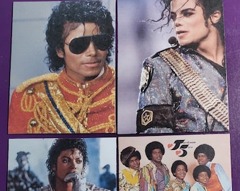 May include: A set of four trading cards featuring images of Michael Jackson. The first card shows Michael Jackson wearing a red and gold military-style jacket with sunglasses. The second card shows Michael Jackson wearing a silver sequined jacket with a star on the shoulder. The third card shows Michael Jackson wearing a white leather jacket with a silver studded collar. The fourth card shows Michael Jackson with four other men wearing colorful clothing. The text "Jackson 5" is printed on the card.