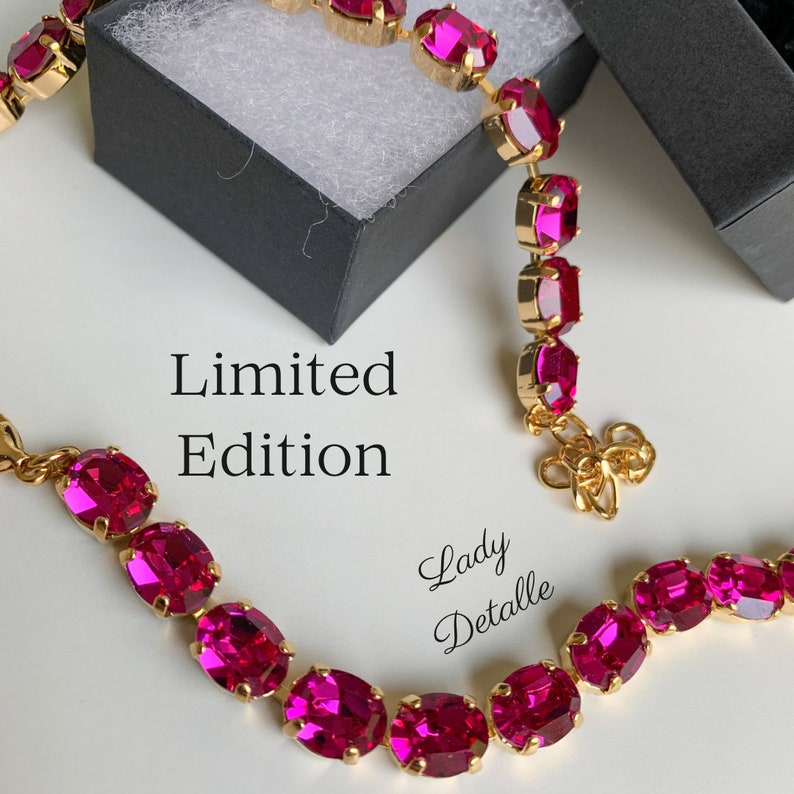 May include: Two gold necklaces with oval shaped pink gemstones. The necklaces are on a white surface. The text 'Limited Edition' and 'Lady Detalle' are visible in the image.