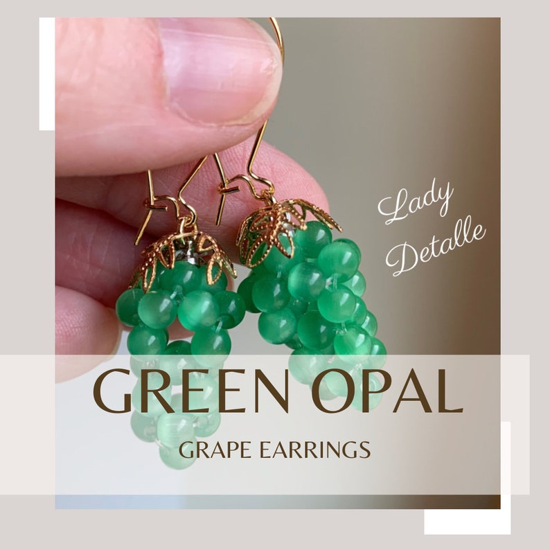 May include: Green opal grape earrings with gold accents. The earrings are made of small, round beads that are strung together to form a grape cluster. The earrings are hanging from gold hooks.